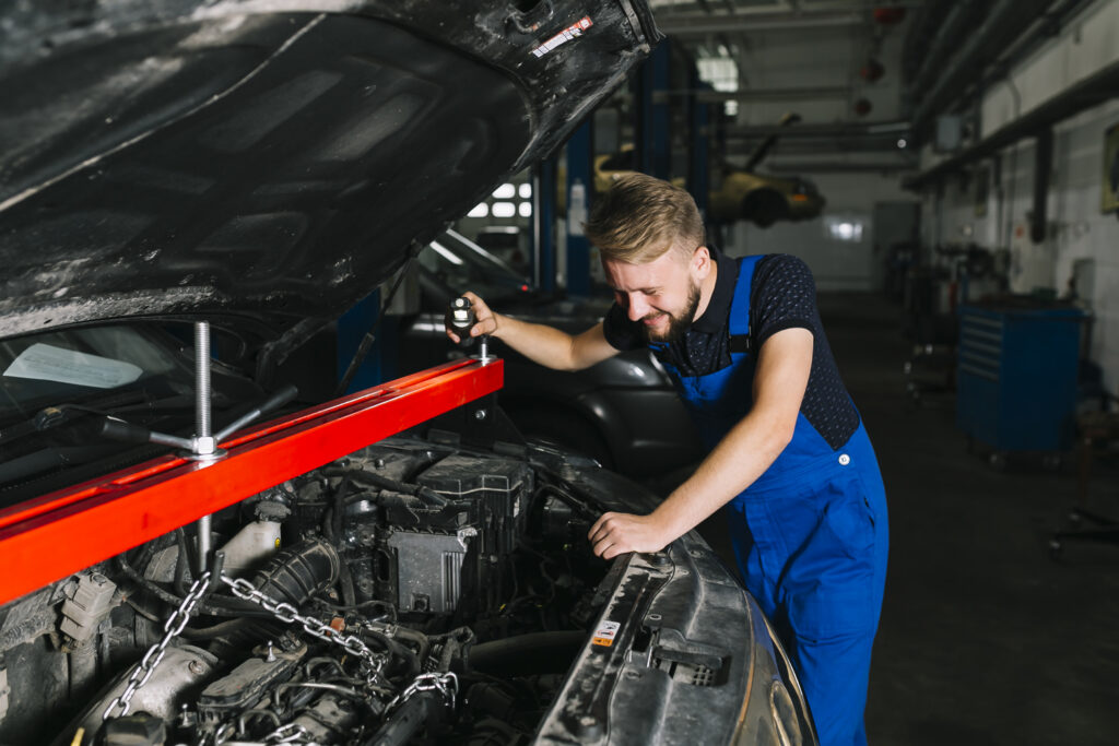 auto mechanic hoisting out car s engine