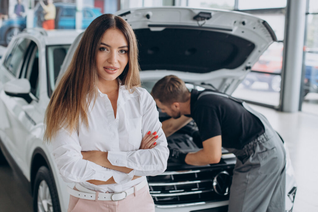 woman at acr service station checking her car with mechanic